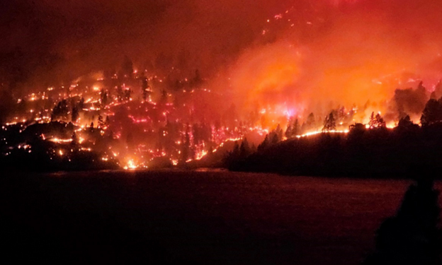 Wildfire at night burning above Okanagan Lake.