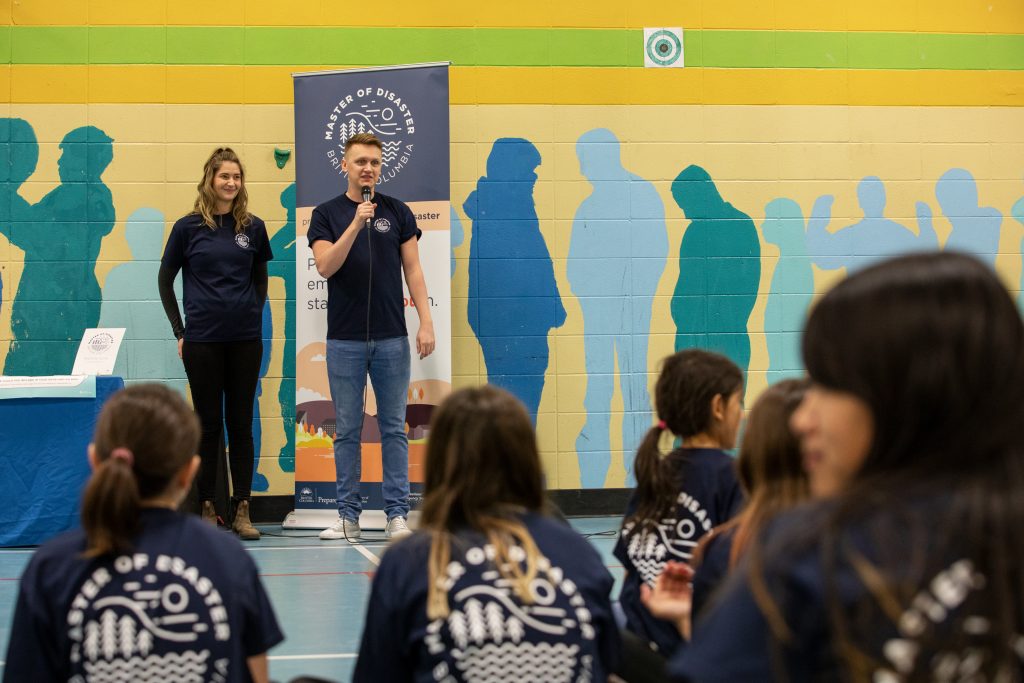 A photo of two Master of Disaster representatives delivering the program to students at a school.