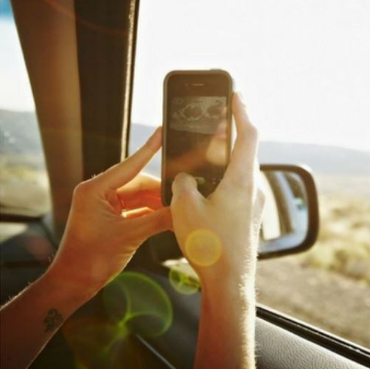 Snapping a photo from the passenger seat of car on a sunny day. 